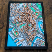 Framed 3D city map on a wooden surface