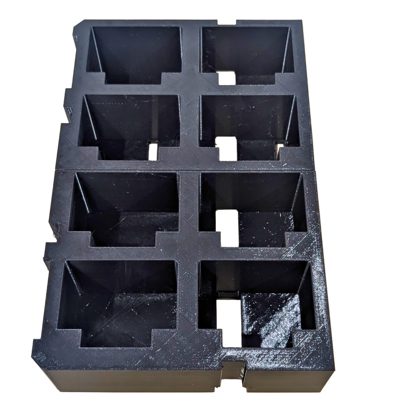 Black foam packaging tray with compartments on a wooden surface