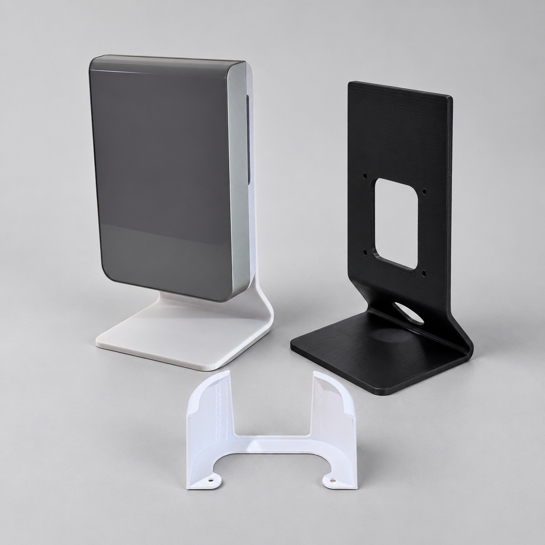 White stand holding a UniFi access point, a black desktop stand and a white Eero wall bracket.